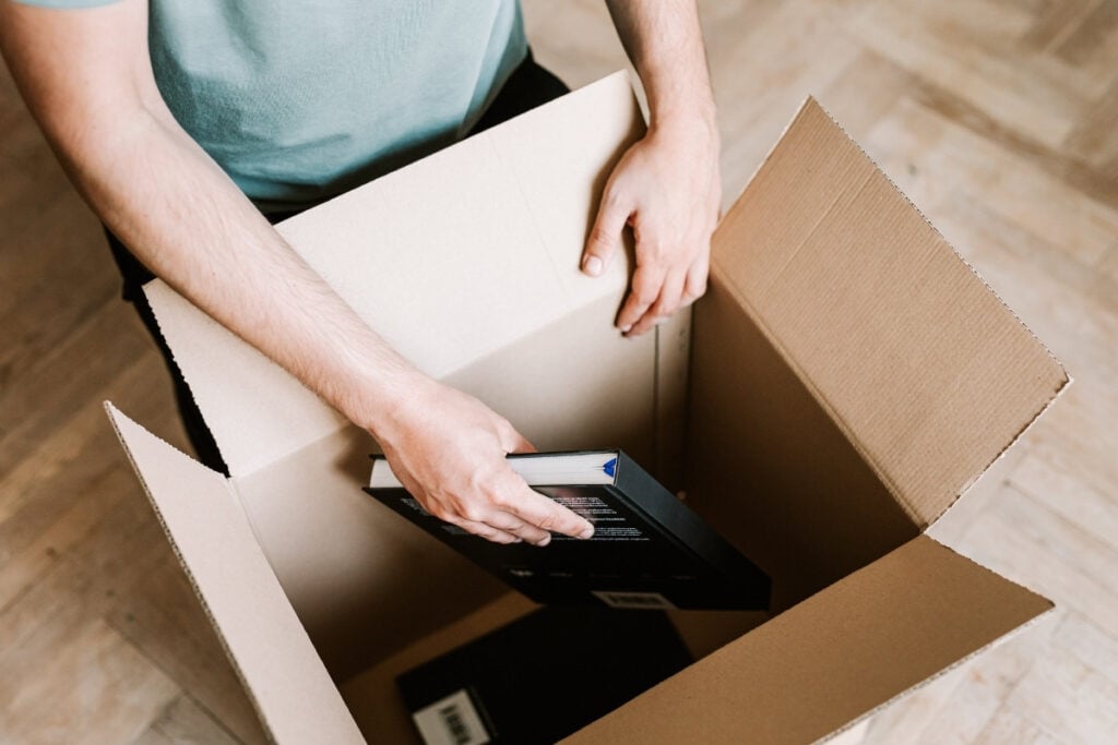 Placing books into a moving box.