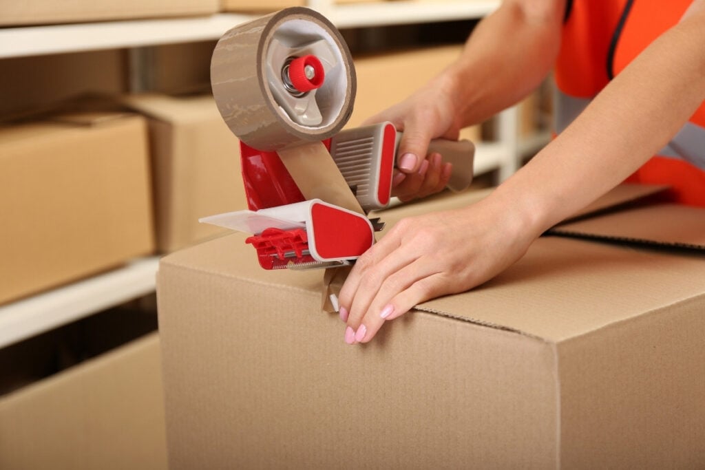 Sealing a moving box with packing tape.