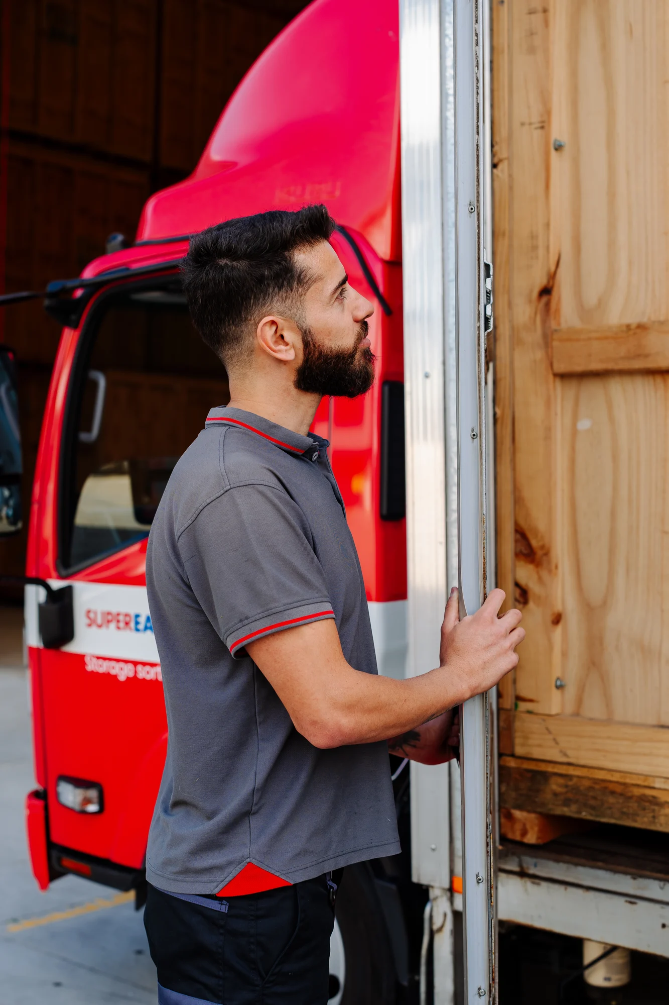 Super Easy Storage team member loading a container beside a red truck